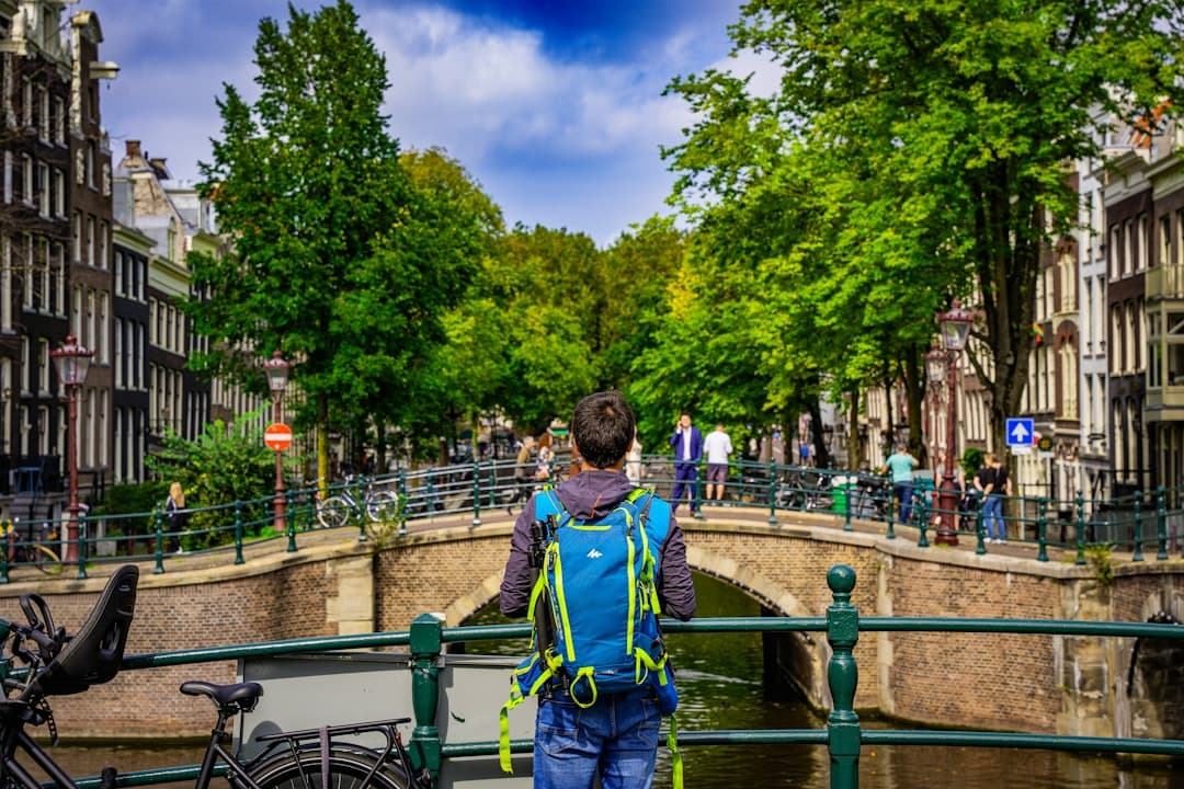 a man walking across a bridge over a river - Photo by Eryk Piotr Munk on Unsplash
