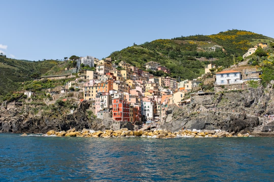 Colorful village clinging to a rocky cliffside by the sea. - Photo by Leslie Heintz on Unsplash