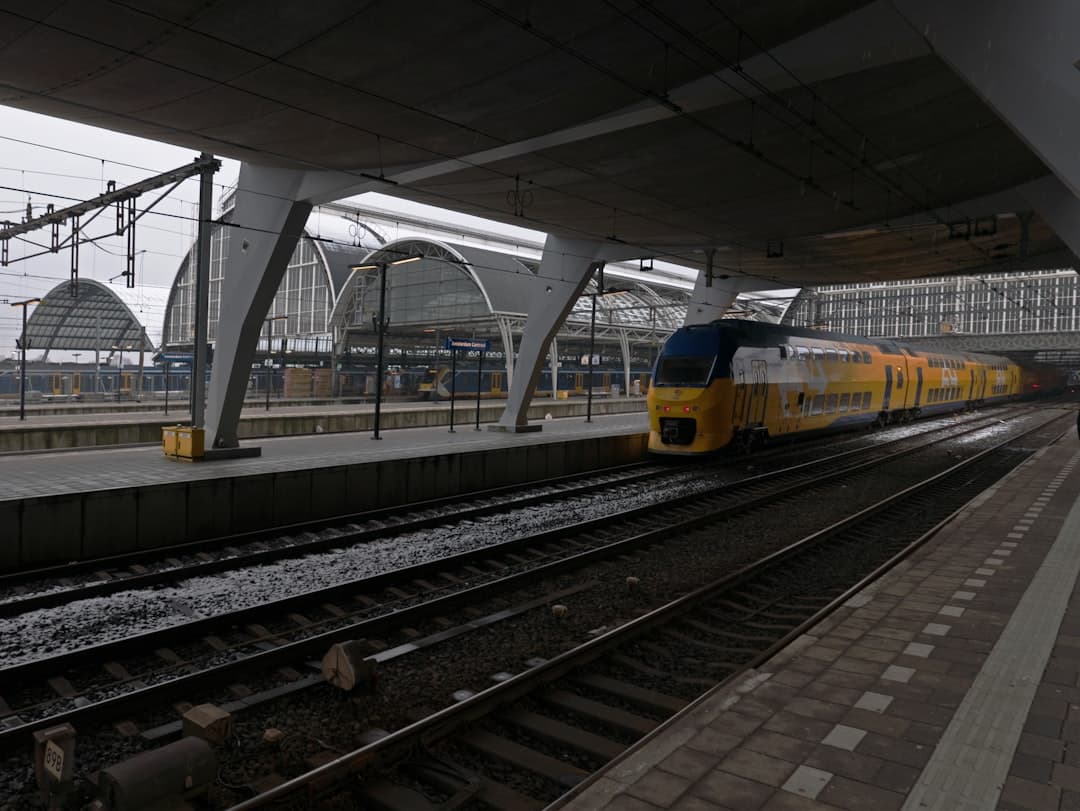 A yellow train at a modern station platform. - Photo by Fons Heijnsbroek on Unsplash