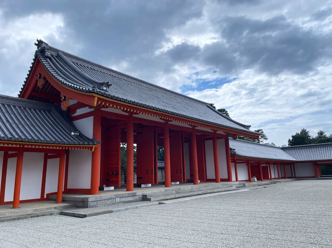 a red and white building with a sky background - Photo by Ronin on Unsplash